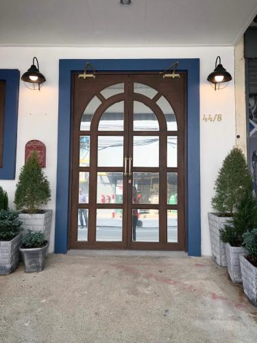 a front door of a building with two potted plants at Hide and Seek Boutique Hometel in Bangkok