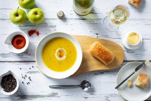 a bowl of soup and a piece of bread on a cutting board at Unembeza Boutique Lodge & Spa in Hoedspruit