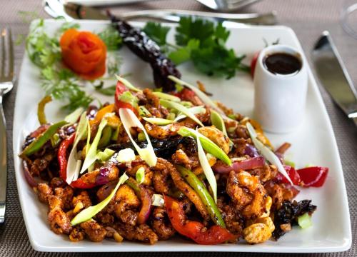 a white plate of food on a table at Fun Retreat Resort, Hotel and Ayurveda Spa in Arusha