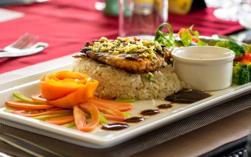 a plate of food with rice and vegetables on a table at Fun Retreat Resort, Hotel and Ayurveda Spa in Arusha