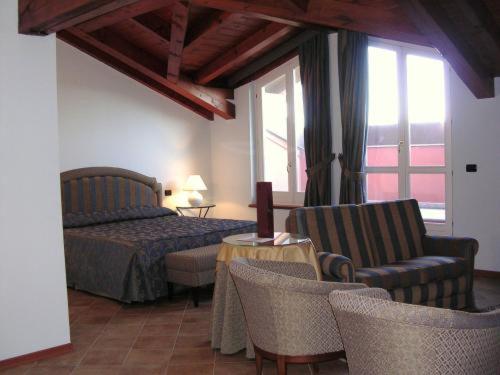 a bedroom with a bed and a table and chairs at La Locanda del Melograno in Moncalvo