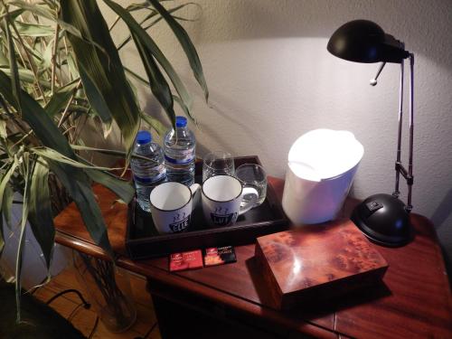 a tray with water bottles and glasses on a table at Les Remparts in Binche