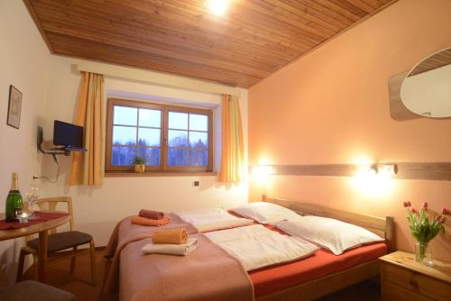 a bedroom with two beds and a window and a table at Penzion Mašek in Cheb