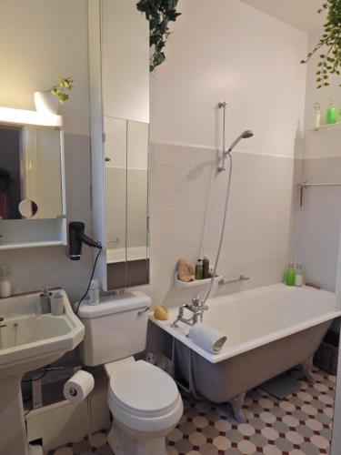 a bathroom with a tub and a toilet and a sink at Les Remparts in Binche
