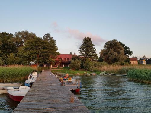 a group of boats docked at a dock on a river at Villa Maximilian in Srokowo