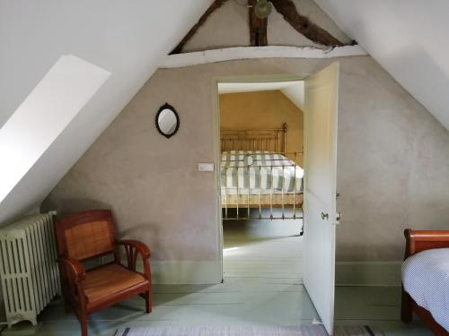 a attic bedroom with a bed and a chair at La "charcuterie" GREBER in Beauvais