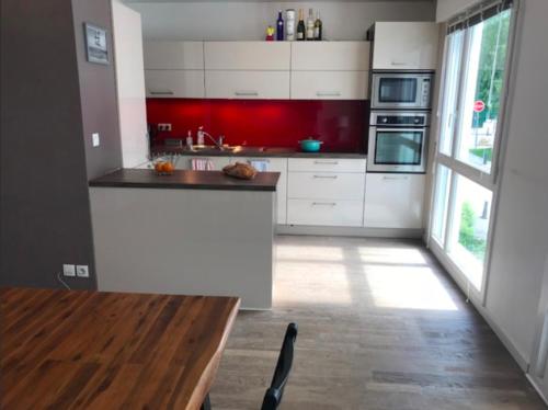 une cuisine avec des armoires blanches et une table en bois dans l'établissement Spacious modern 2 bedroom flat great location old town + lake, à Annecy