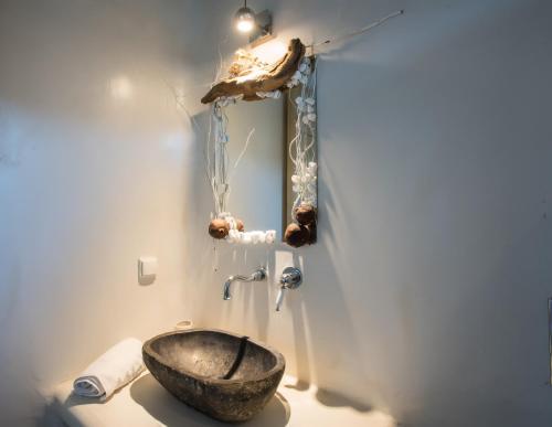 a bathroom with a stone sink and a mirror at Amallini Suites Mykonos in Super Paradise Beach
