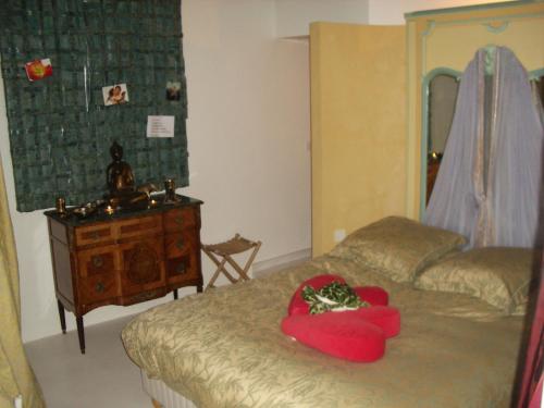 une chambre avec un lit avec un oreiller rouge dessus dans l'établissement 8 Place du Tertre, à Paris