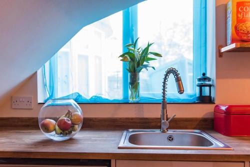 馬蓋特的住宿－Garden Oasis，厨房水槽,窗户旁有一碗水果
