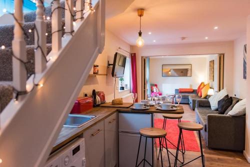a kitchen with two stools in a kitchen with a living room at Garden Oasis in Margate