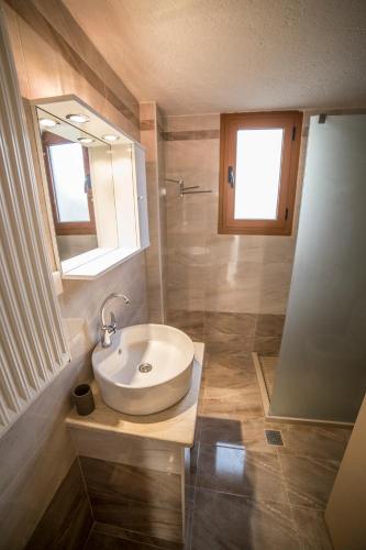 un baño con lavabo y espejo en Bay View Apartments, en Sitia