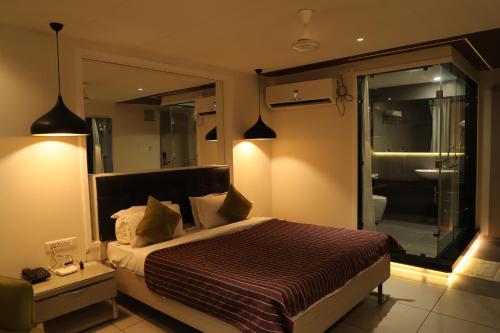 a bedroom with a bed and a window with a bathroom at Hotel KC Palace in Bhopal