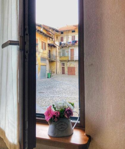 a vase with flowers sitting on a window sill at PICCOLA VILLA nel Centro Storico in Arona