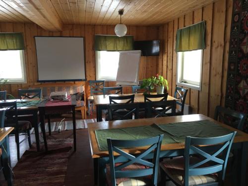 a dining room with tables and chairs and a whiteboard at Leipyölin tila in Perniö