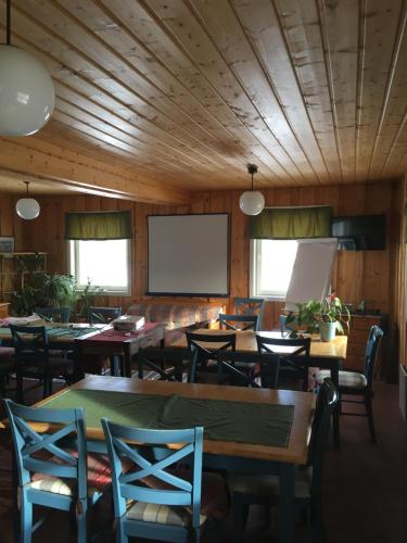 a conference room with tables and chairs and a screen at Leipyölin tila in Perniö
