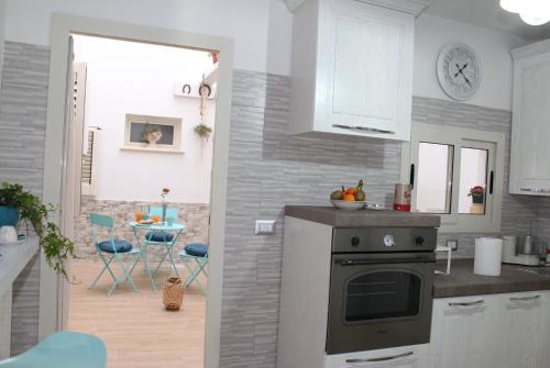 a kitchen with a stove and a kitchen with a table at Casa Vacanze: Le Tre Stelle in Nardò