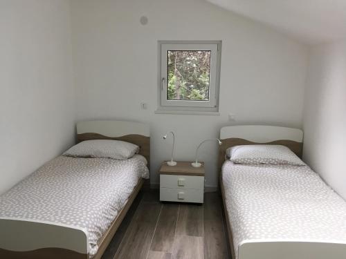 two twin beds in a room with a window at Casa Vacanze Como Brunate in Brunate