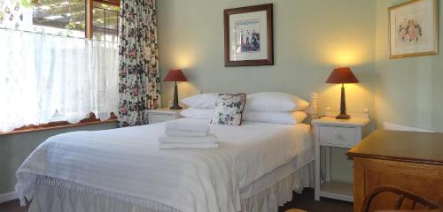 a bedroom with a bed with towels on it at Braeview Guest House in Hermanus