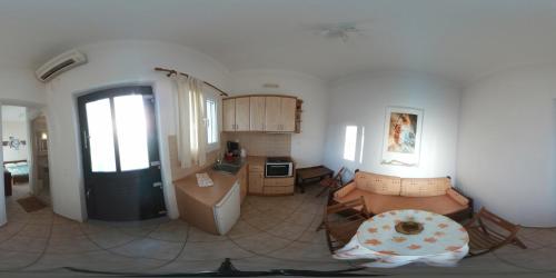 a living room with a kitchen and a door at Anastasia Studios in Tinos Town