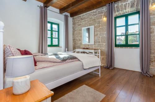 a bedroom with a bed and a brick wall at Dvor strica Grge in Kaštelir