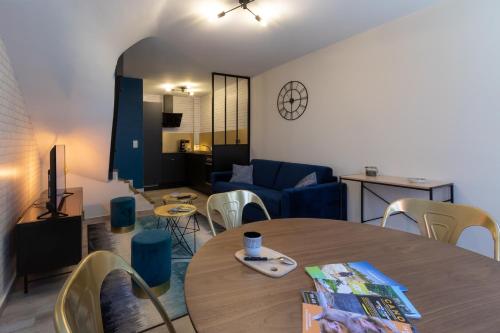 ein Wohnzimmer mit einem Tisch und einem Sofa in der Unterkunft Maison de centre ville in Souillac