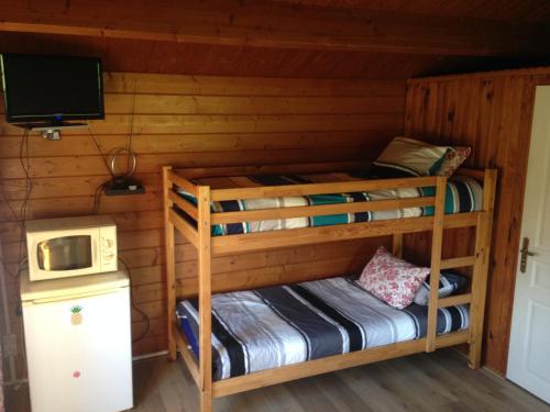 a room with two bunk beds and a microwave at CHALET GOYAVE in Épaignes