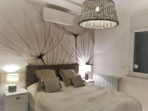 a bedroom with a large bed and a chandelier at EXCELSIOR 10 - Luxury apartment in Grado