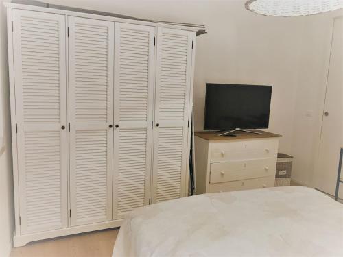una camera con un letto e un comò con una televisione di EXCELSIOR 10 - Luxury apartment a Grado