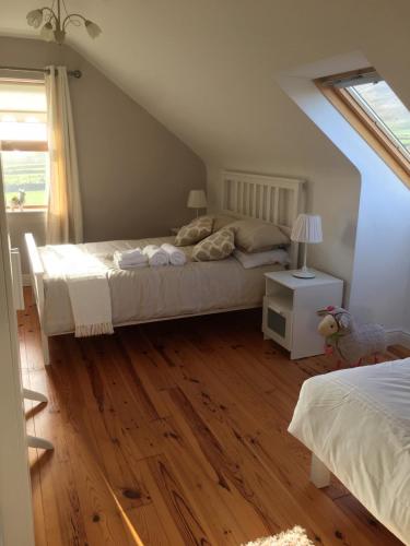 a bedroom with a bed and a wooden floor at Gort a Phump in Ballydavid