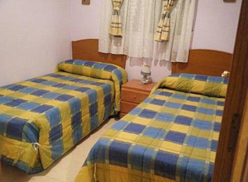 Un dormitorio con dos camas y una ventana. en Marina dort Acapulco II primera línea de playa, en Oropesa del Mar