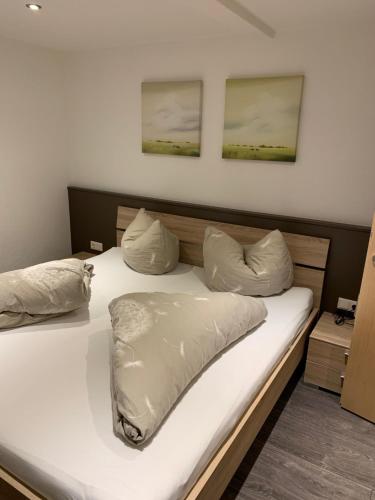 フューゲンにあるFerienwohnung Mauracher Kirer Hausのベッドルーム1室(白いシーツと枕のベッド1台付)