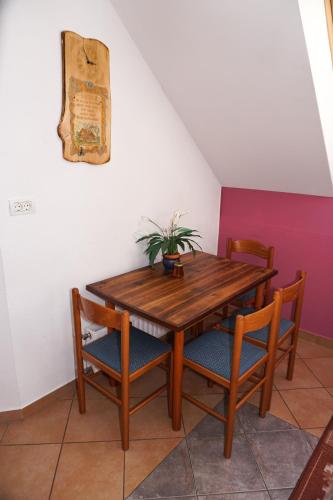 a wooden table and chairs with a plant on it at Apartment Ozebek in Cerkno
