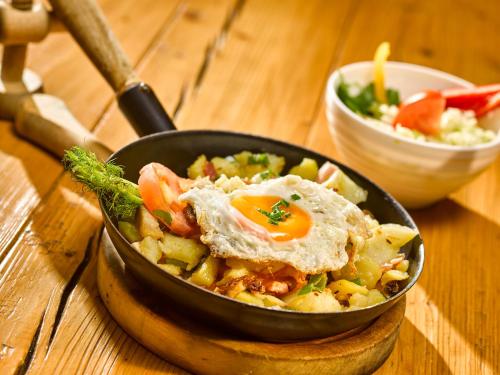 a bowl of food with an egg on a table at Alpengasthof Hochsöll in Söll