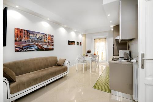 ein Wohnzimmer mit einem Sofa und einer Küche in der Unterkunft Ludovisi Barberini Grand Apartment in Rom