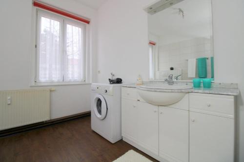 a white bathroom with a sink and a washing machine at Ferienwohnungen Schneider in Görlitz