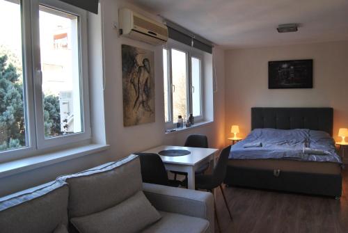 莫斯塔尔APARTMAN QUEEN的一间卧室，里面有一张床、一张桌子和几把椅子。