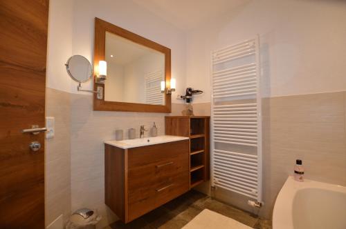ein Badezimmer mit einem Waschbecken, einem Spiegel und einem WC in der Unterkunft Apart Lorenz in Häselgehr