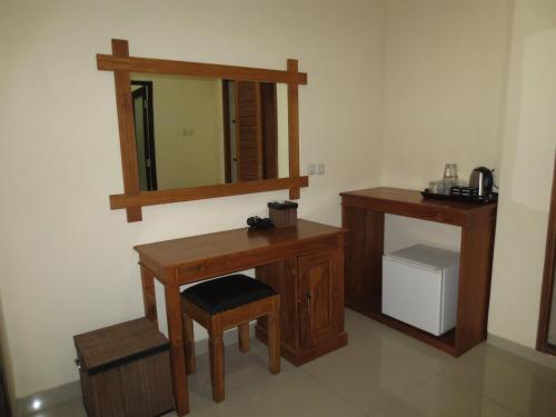 a bathroom with a wooden vanity and a mirror at Swastika Bungalows in Sanur