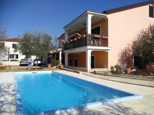een huis met een zwembad voor een huis bij Apartments Majda in Umag
