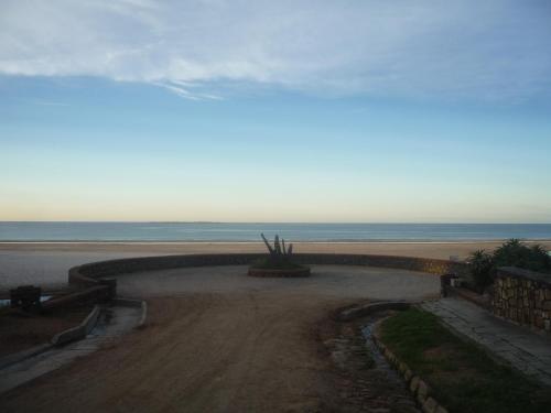 a dirt road next to a beach with the ocean at La Cabaña in San Luis