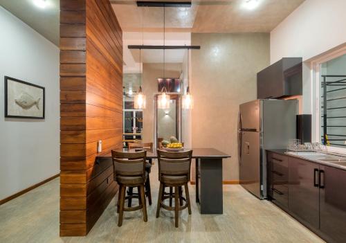 a kitchen with a table and a refrigerator at Hikka Hill Loft in Hikkaduwa