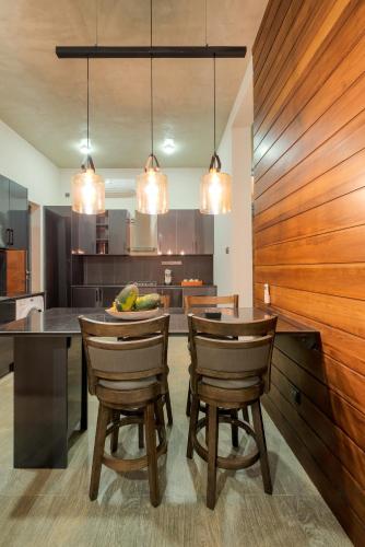 a kitchen with a dining table with chairs and lights at Hikka Hill Loft in Hikkaduwa