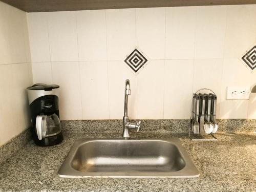 un lavandino in acciaio inossidabile in un bancone della cucina di Aparta hotel TOCANCIPA con Parqueadero y Wifi a Tocancipá