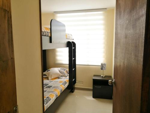 a bunk bed in a room with a mirror at Aparta hotel TOCANCIPA con Parqueadero y Wifi in Tocancipá
