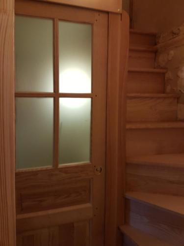 a glass door in a room with stairs at Le bourgis in La Chapelle-Montligeon