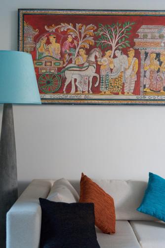 a painting on the wall above a couch with pillows at Hikka Hill Loft in Hikkaduwa