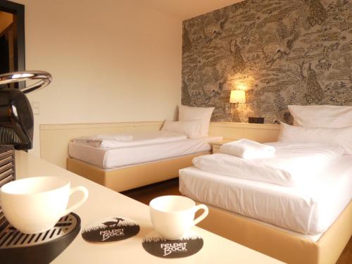 ein Hotelzimmer mit 2 Betten mit Tassen auf einem Tisch in der Unterkunft Hotel Restaurant Felderbock in Nußloch