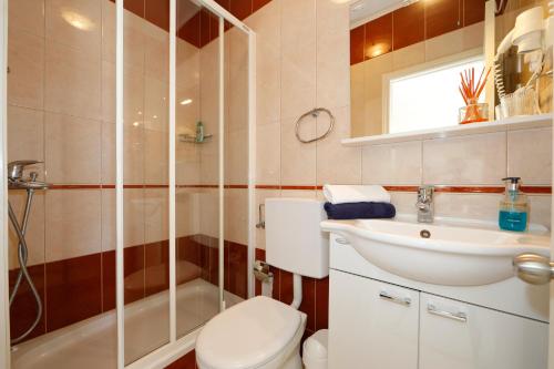 a bathroom with a toilet and a sink and a shower at Apartments Villa Lili in Tučepi