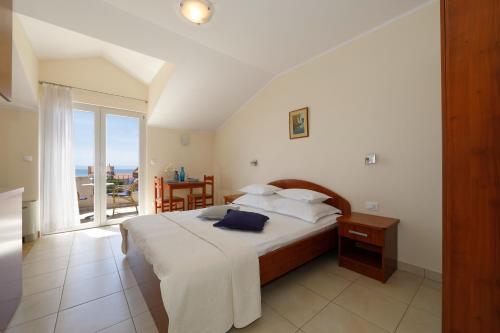 a bedroom with a bed and a view of the ocean at Apartments Villa Lili in Tučepi